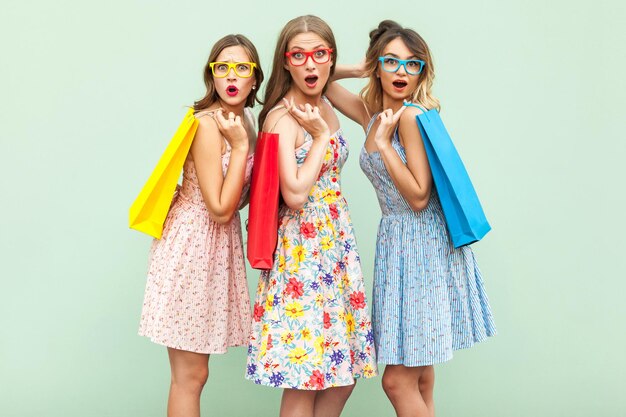 Retrato de tres chicas maravilla con paquetes y ropa nueva