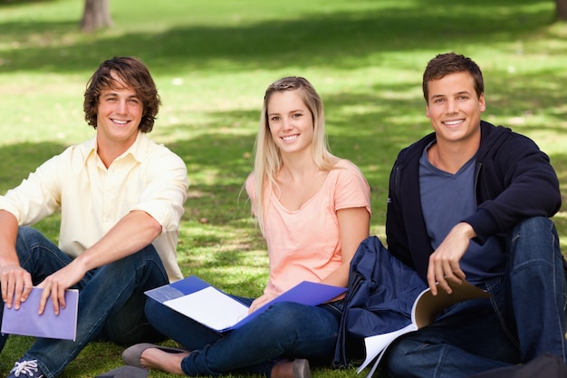 Retrato de tres estudiantes en un parque