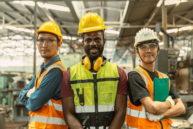 Retrato de tres hombres ingeniero trabajador equipo de pie con los brazos cruzados seguros feliz sonrisa grupo de personas de la industria mezclar raza