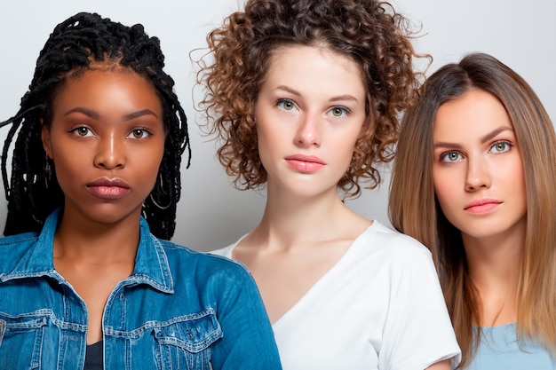 Foto retrato de tres mujeres de diferentes grupos étnicos contra un fondo blanco