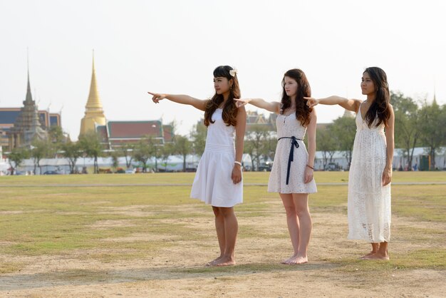 Retrato de tres mujeres hermosas jóvenes multiétnicas como amigos juntos en el parque al aire libre