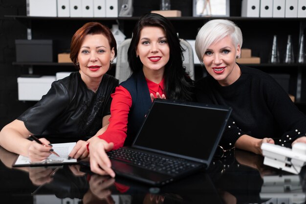 Retrato de tres mujeres de negocios en el trabajo en la oficina con estilo