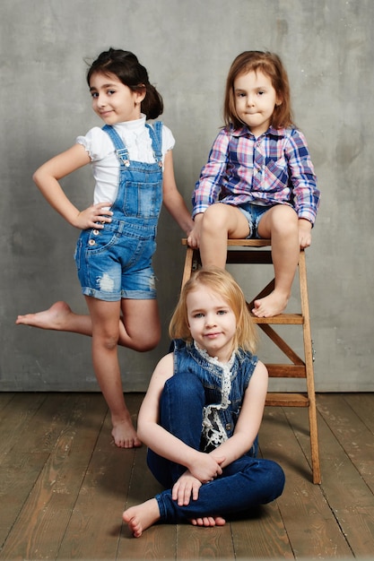 Retrato de tres novias de niñas en el fondo de un muro de hormigón