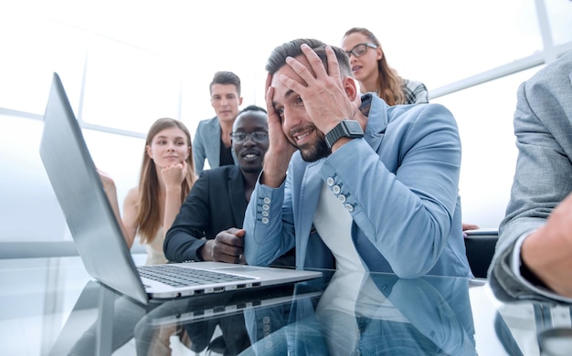 Retrato de tres personas de negocios atractivas y elegantes sentadas juntas en la estación del lugar de trabajo mirando la pantalla de la computadora portátil con una expresión de disgusto infeliz que tiene problemas fallan