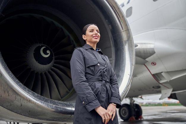 Retrato de la tripulación del avión caucásico seguro feliz cerca del avión