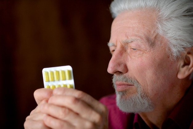 Retrato de triste anciano enfermo con pastillas