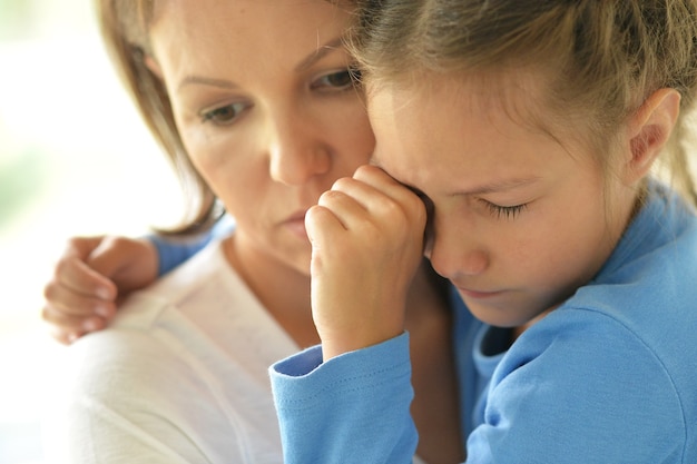 Foto retrato de triste madre e hija en casa