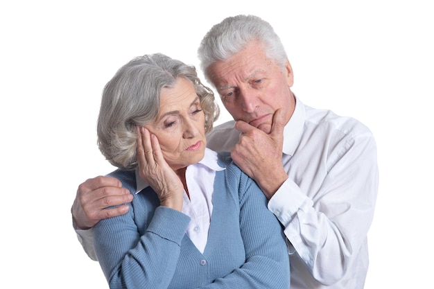 Retrato de una triste pareja de ancianos posando aislada sobre fondo blanco