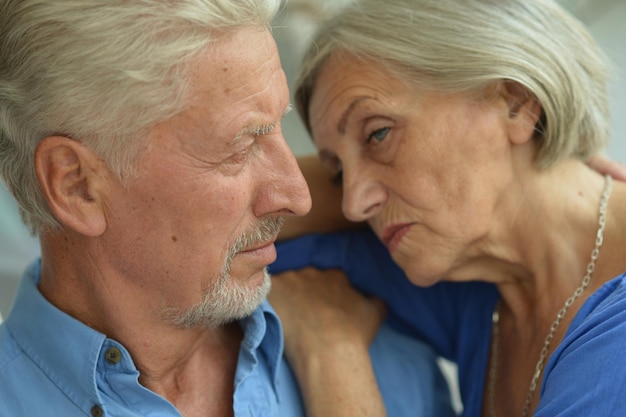 Retrato de una triste pareja de ancianos posando en casa