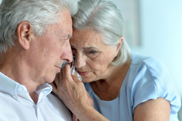 Retrato de una triste pareja de ancianos posando en casa