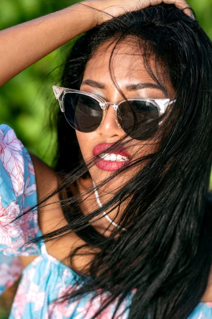 Retrato tropical de una hermosa mujer asiática posando en una playa exótica, vacaciones de lujo, con traje de lino de moda y gafas de sol. isla tailandesa.