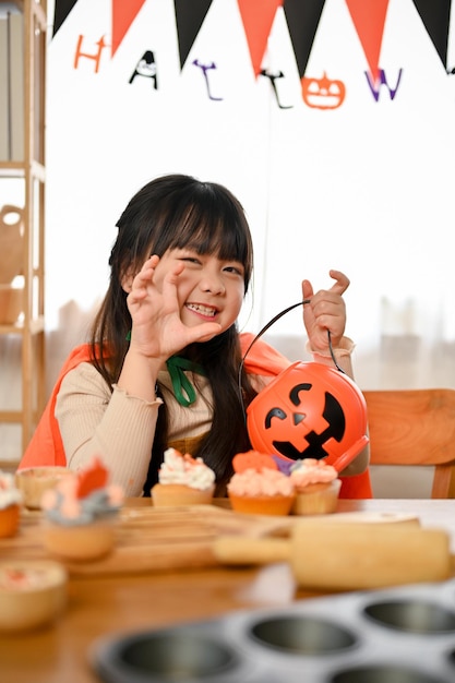 Retrato Uma adorável jovem asiática em traje de Halloween posando uma cara fofa de peekaboo