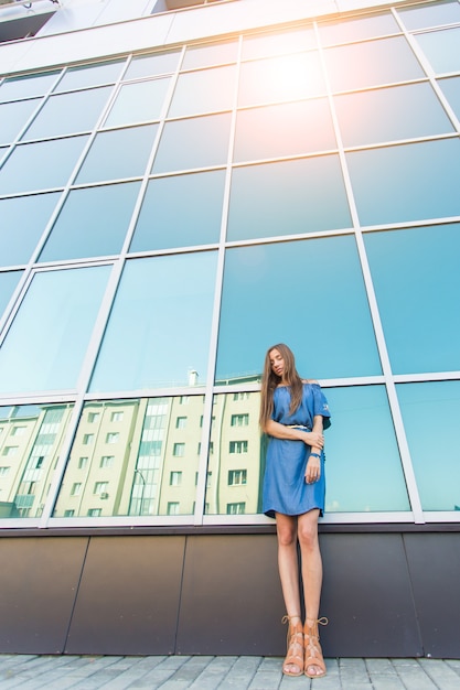 Retrato urbano de moda de bella modelo en la calle. Joven mujer delgada con vestido azul