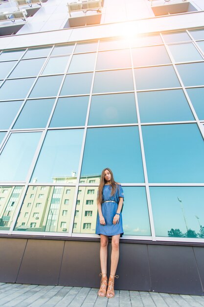 Retrato urbano de moda de bella modelo en la calle. Mujer joven delgada con vestido azul en la ciudad.