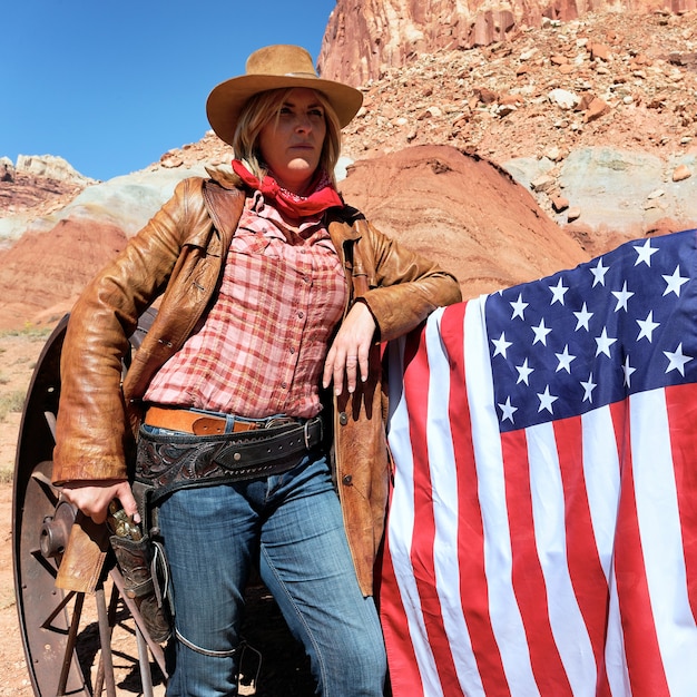 Foto retrato de una vaquera rubia con bandera americana