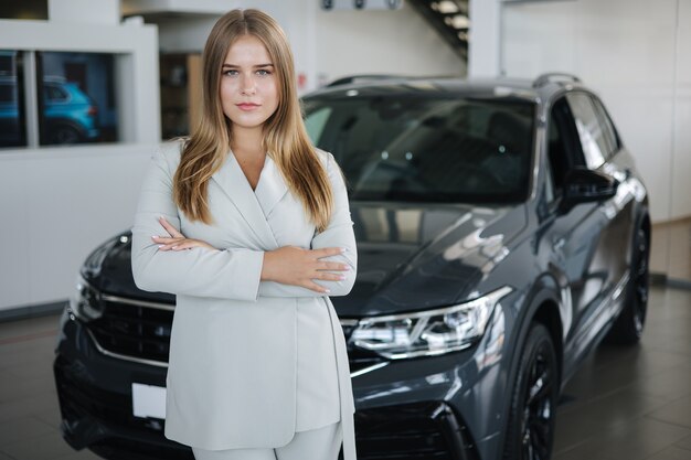 Foto retrato, de, vendedor, en, coche, showroom, atractivo, mujer joven, stend, delante de, coche