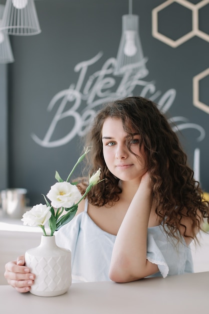 Retrato de verano de una hermosa chica romántica con un vestido en el interior