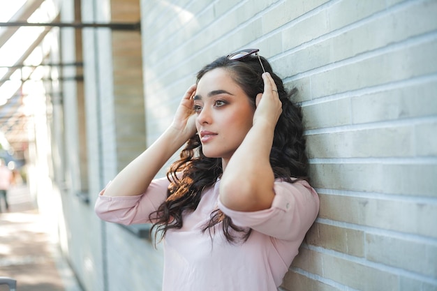 Retrato de verano de una joven y hermosa mujer feliz de cabello oscuro y rizado con ropa informal en las calles de una ciudad europea Retrato soleado de la modelo Vida en la calle