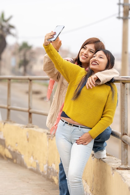 Retrato vertical de amigos tomando selfie al aire libre