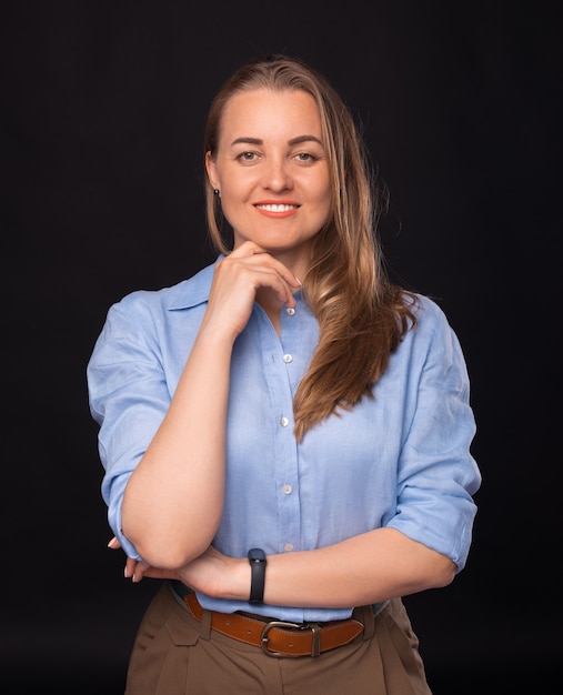 Retrato vertical de jovem mulher de negócios com os braços cruzados, olhando para a câmera