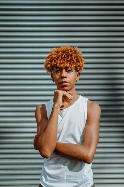 Retrato vertical de um adolescente bonito com boa aparência e maquiagem estilosa posando para a câmera