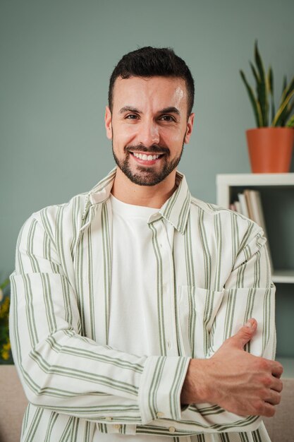 Retrato vertical de um cara bonito com dentes brancos perfeitos sorrindo em casa vista frontal de jovens