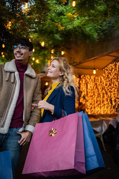 Retrato vertical de um casal com sacolas de compras na cidade