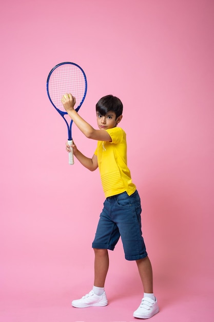Retrato vertical de um menino concentrado jogando tênis