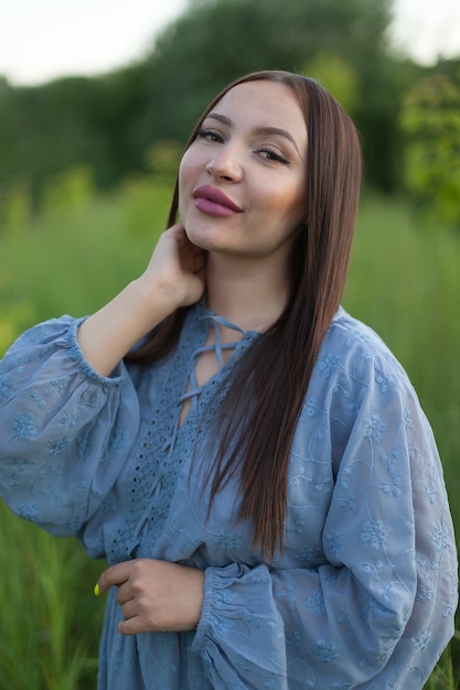 Retrato vertical de uma bela jovem em um campo. garota em espigas de trigo em um campo quente de verão ao ar livre.