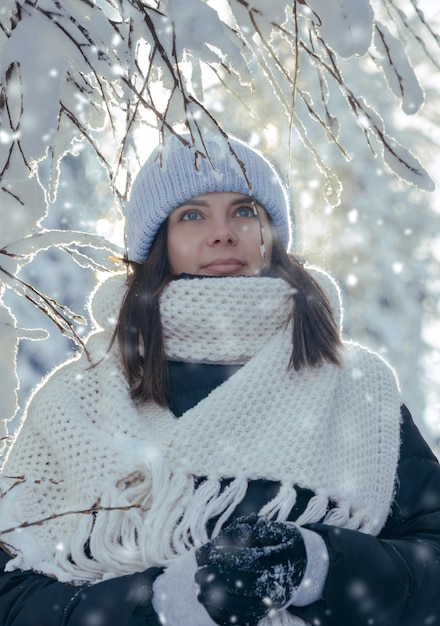 Retrato vertical de uma mulher com roupas quentes em clima de neve