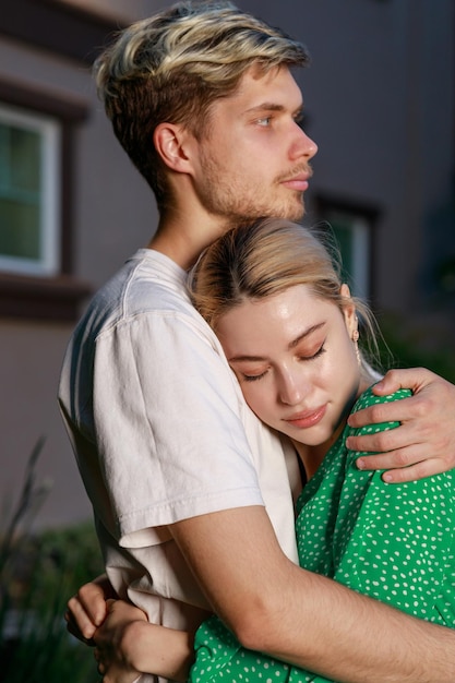Retrato vertical do jovem casal se abraçando na rua