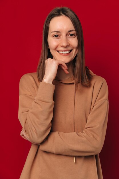 Retrato vertical de estudio de una joven linda mujer sonriendo a la cámara