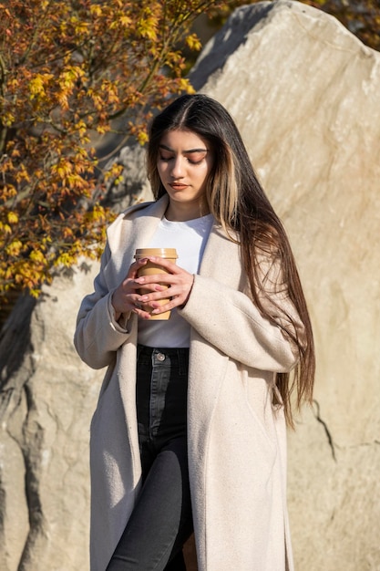 Retrato vertical de una joven hermosa con una taza de café Foto de alta calidad