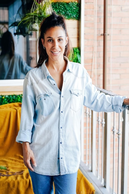 Retrato vertical de una joven mujer caucásica mirando a la cámara sonriendo