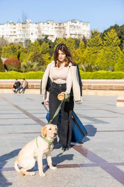 Retrato vertical de una joven con un perro adorable en el parque Foto de alta calidad