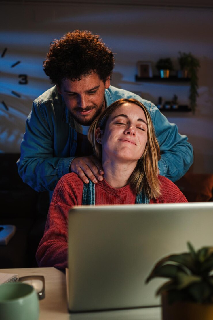 Foto retrato vertical de una mujer cansada y estresada por trabajar con una computadora portátil recibe masaje y caricias