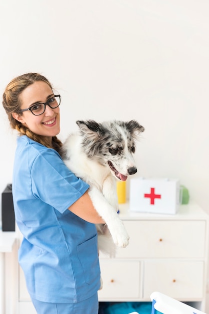 Foto retrato de un veterinario mujer feliz con perro