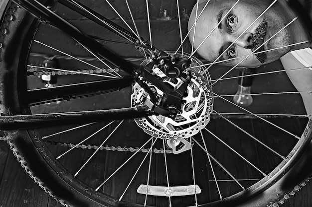 retrato vintage de um homem de bigode consertando uma roda de bicicleta, hipster excêntrico