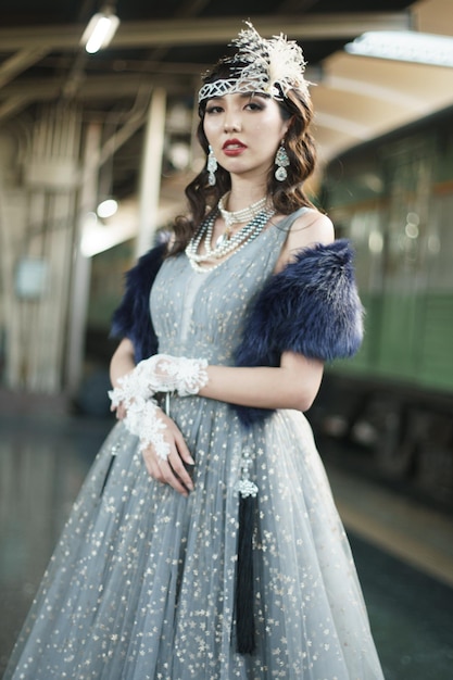 Retrato vintage retrô da bela mulher de Gatsby, olhe ao redor, espere o trem para o amante, sentindo a expressão do rosto romântico estilo de moda dos anos 20 na estação de trem pública, conceito de moda antiga de Gatsby