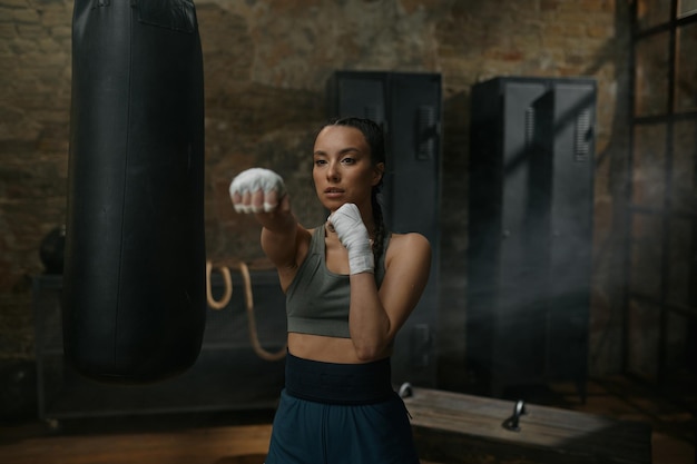 Retrato de vista frontal de una poderosa boxeadora luchando contra la cámara