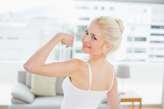 Retrato de la vista posterior de la mujer apta que dobla los músculos