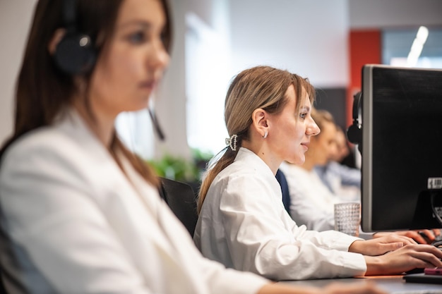 Retrato de vista trasera de una mujer de negocios sentada en su lugar de trabajo en la oficina escribiendo mirando la pc