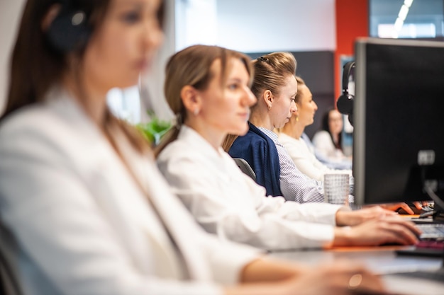 Retrato de vista trasera de una mujer de negocios sentada en su lugar de trabajo en la oficina escribiendo mirando la pc