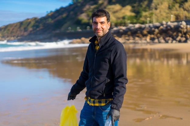 Retrato voluntário coletando lixo e plástico na praia conceito de ecologia poluição do mar