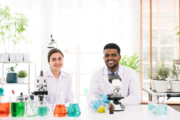 Retratos de uma diversidade de cientistas sorrindo e olhando para a câmera em um laboratório de pesquisa.