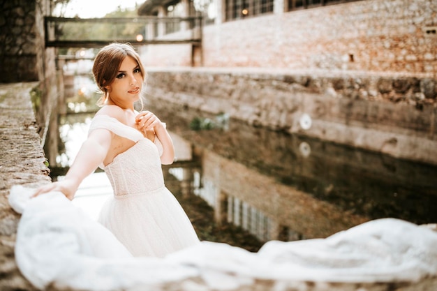 Retratos de ensueño de hermosa novia en la orilla del río de piedra