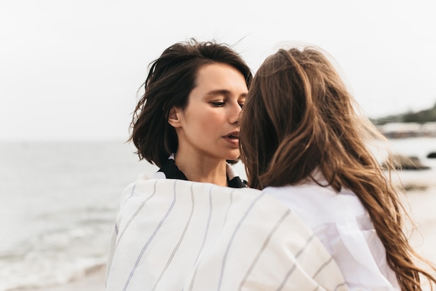 Retratos de mamá e hija en la playa del mar.