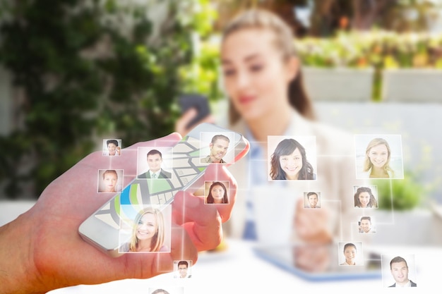 Foto retratos sonrientes contra el hombre usando la aplicación de mapa en el teléfono