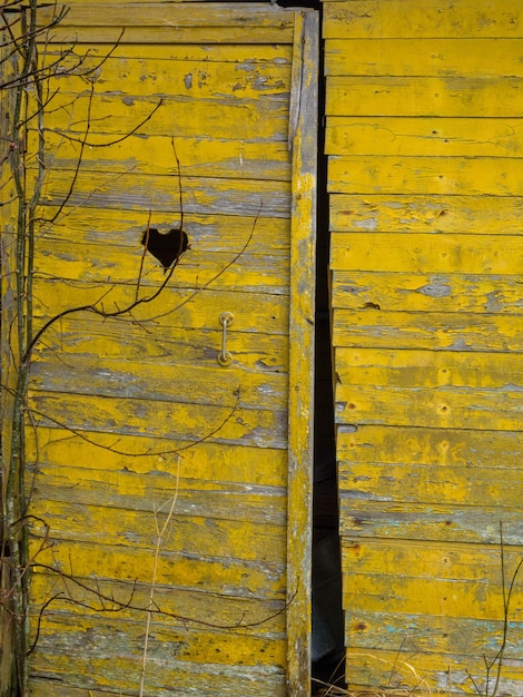 Retrete de madera en el jardín con un agujero en forma de corazón en la puerta