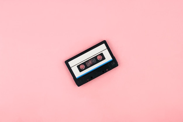Retro Audio-Kassette flach lag auf buntem blau-rosa Pastellhintergrund. Draufsicht mit Kopierraum. Kreatives Modedesign im minimalistischen 80er-Jahre-Stil mit Duotones.